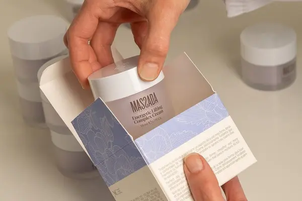 kobieta wyciąga z pudełka krem z kwasem hialuronowym